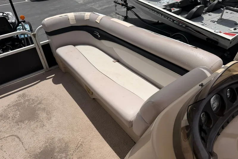 Slide: The Image of 2011 Bennington 20SLi boat interior with beige seating and dashboard. - 14