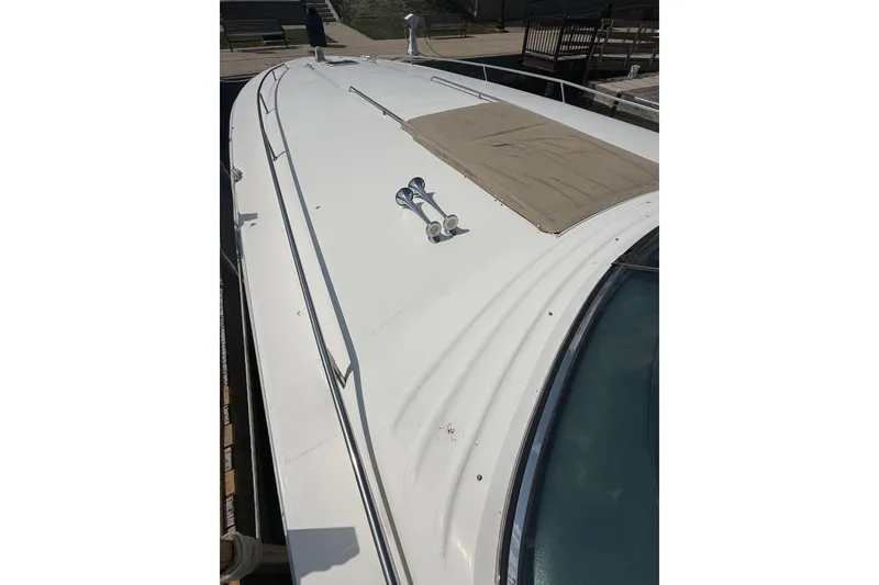 Slide: The Image of 1991 Sea Ray 630 Super Sun Sport yacht deck with beige cover and chrome horns. - 5