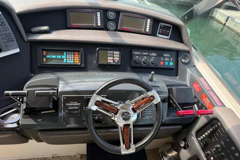 Slide: The Image of Cockpit of 1991 Sea Ray 630 Super Sun Sport with steering wheel and control panels. - 25