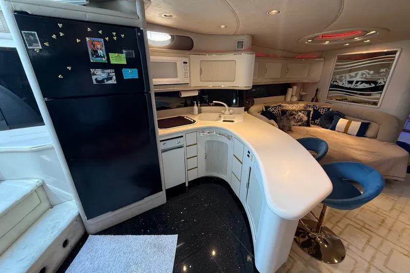 Slide: The Image of Luxurious interior of 1991 Sea Ray 630 Super Sun Sport yacht with modern kitchen and seating area. - 33