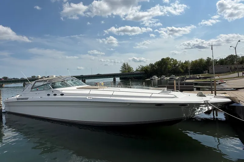 Slide: The Image of A 1991 Sea Ray 630 Super Sun Sport docked on calm water under a sunny sky. - 1