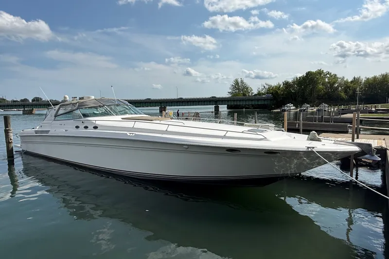The Image of 1991 Sea Ray 630 Super Sun Sport yacht docked in a serene marina setting. - 0