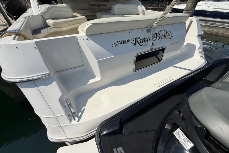 Slide: The Image of 1991 Sea Ray 630 Super Sun Sport yacht docked, featuring spacious seating and elegant design. - 12