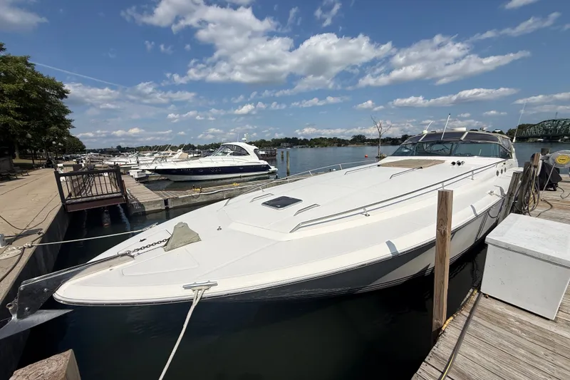 Slide: The Image of 1991 Sea Ray 630 Super Sun Sport yacht docked at a marina under a blue sky. - 3
