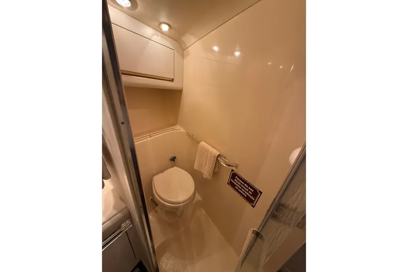 Slide: The Image of Compact bathroom in 1991 Sea Ray 630 Super Sun Sport yacht, featuring toilet and storage. - 40