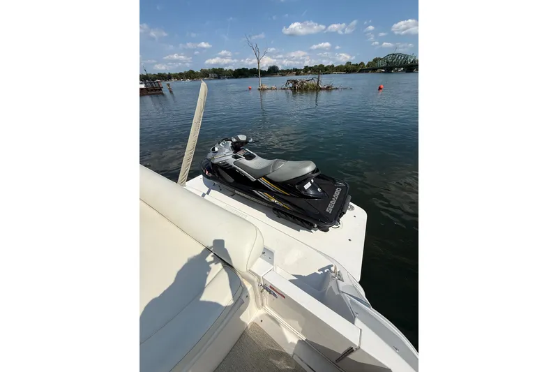 Slide: The Image of Sea Ray 630 Super Sun Sport 1991 with Sea-Doo jet ski on deck, scenic water view. - 10