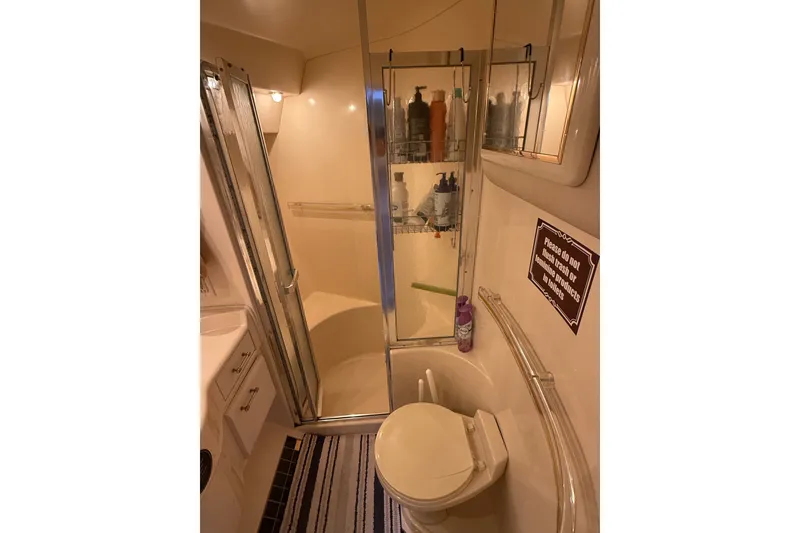 Slide: The Image of Bathroom interior of 1991 Sea Ray 630 Super Sun Sport yacht, featuring shower and toilet. - 46