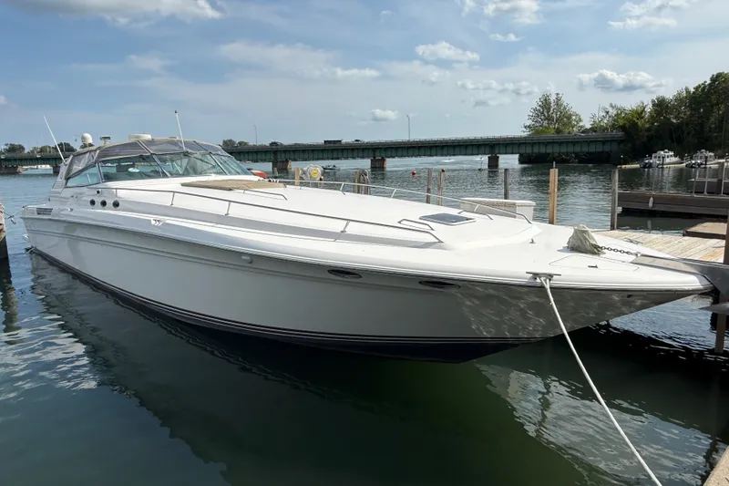 Slide: The Image of 1991 Sea Ray 630 Super Sun Sport yacht docked by a scenic waterfront. - 2