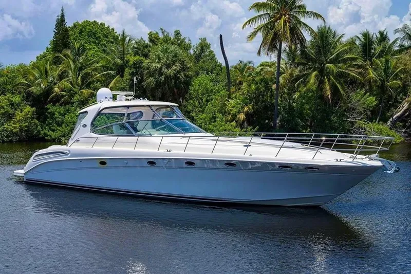 Slide: The Image of 2004 Sea Ray 550 Sundancer yacht cruising on a serene tropical waterway. - 6