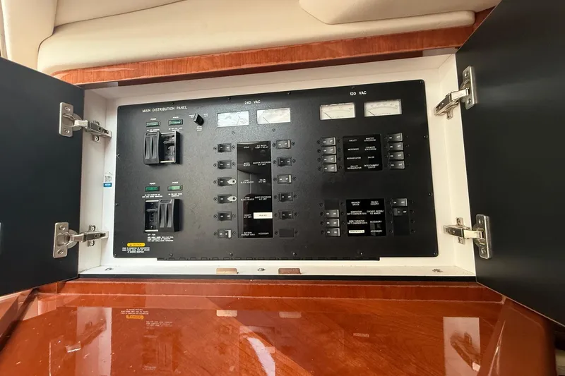 Slide: The Image of Electrical panel inside a 2004 Sea Ray 550 Sundancer yacht, featuring various switches and meters. - 108