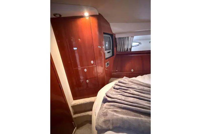 Slide: The Image of Luxurious 2004 Sea Ray 550 Sundancer cabin interior with wood paneling and cozy bedding. - 91