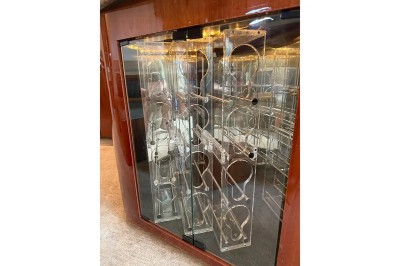 Slide: The Image of Luxurious wine rack inside 2004 Sea Ray 550 Sundancer yacht, featuring elegant glass and wood design. - 12