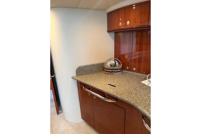 Slide: The Image of 2004 Sea Ray 550 Sundancer interior with wooden cabinets and granite countertop. - 100