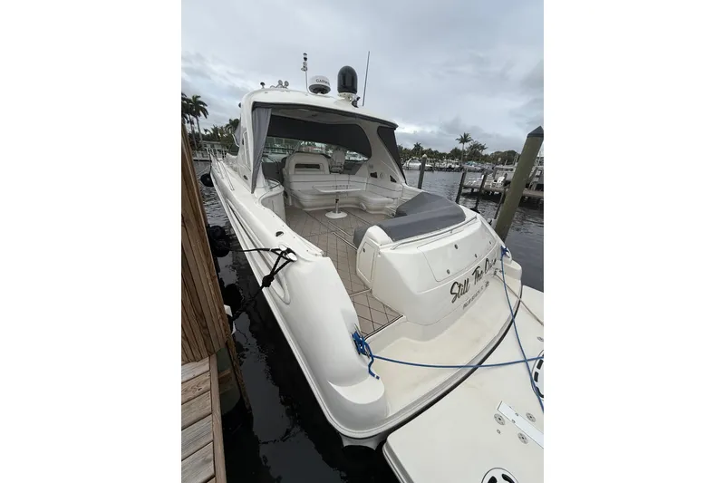 Slide: The Image of 2004 Sea Ray 550 Sundancer yacht docked at marina, featuring spacious deck and seating area. - 45