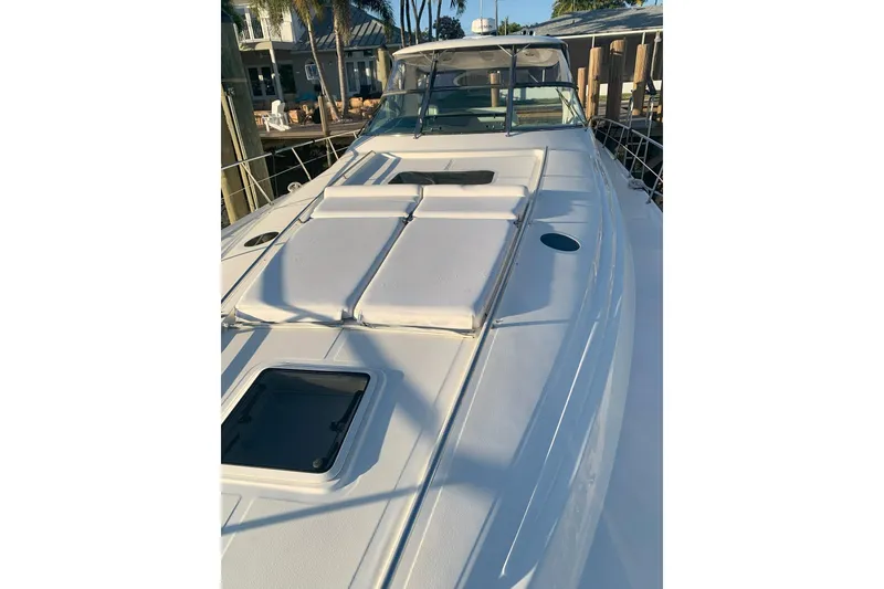 Slide: The Image of 2004 Sea Ray 550 Sundancer yacht with sunbathing deck, docked at marina. - 2
