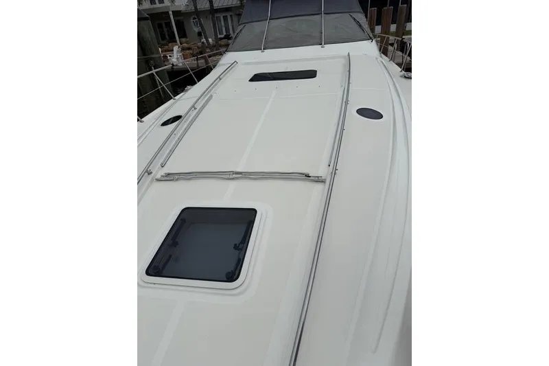 Slide: The Image of 2004 Sea Ray 550 Sundancer yacht deck with hatch and railing. - 83