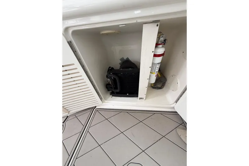 Slide: The Image of Storage compartment on a 2004 Sea Ray 550 Sundancer boat with equipment and fire extinguisher. - 112