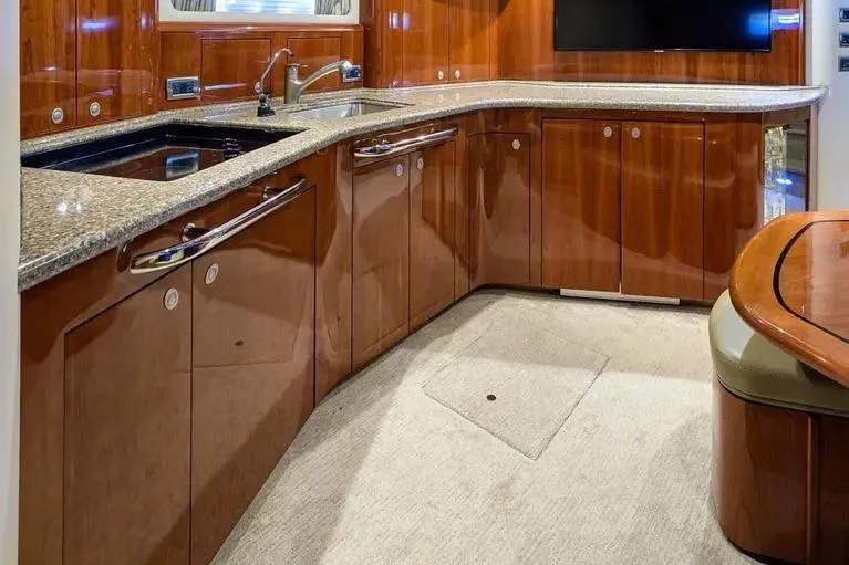 Slide: The Image of Luxurious 2004 Sea Ray 550 Sundancer yacht interior with sleek wooden cabinetry and modern amenities. - 11