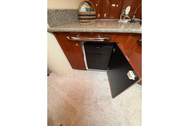 Slide: The Image of 2004 Sea Ray 550 Sundancer interior with open cabinet and granite countertop. - 103