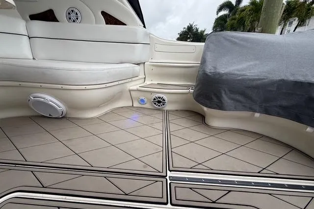 Slide: The Image of 2004 Sea Ray 550 Sundancer boat interior with cushioned seating and modern flooring. - 111