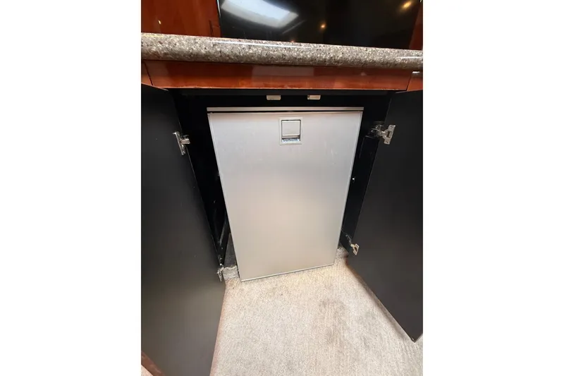 Slide: The Image of Built-in refrigerator on 2004 Sea Ray 550 Sundancer yacht, with open cabinet doors. - 106
