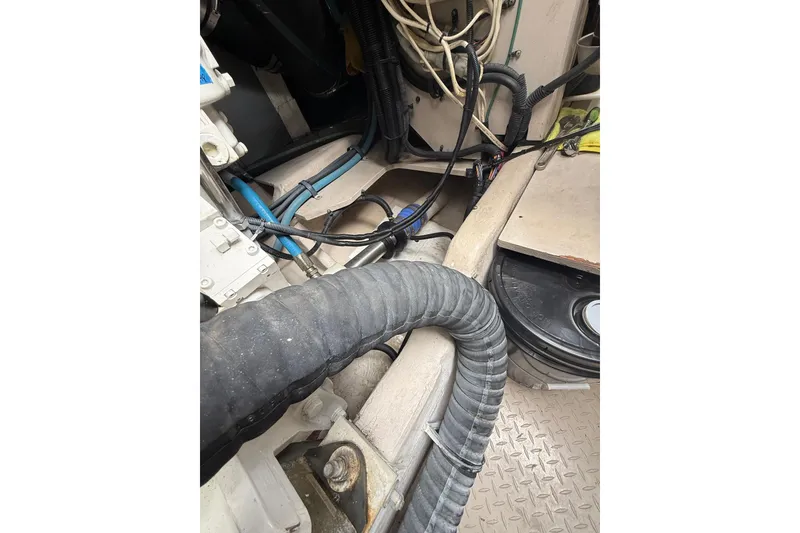 Slide: The Image of Engine compartment of a 2004 Sea Ray 550 Sundancer with visible hoses and wiring. - 54