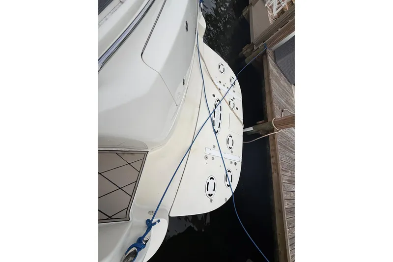 Slide: The Image of 2004 Sea Ray 550 Sundancer yacht docked, showing swim platform and mooring lines. - 76