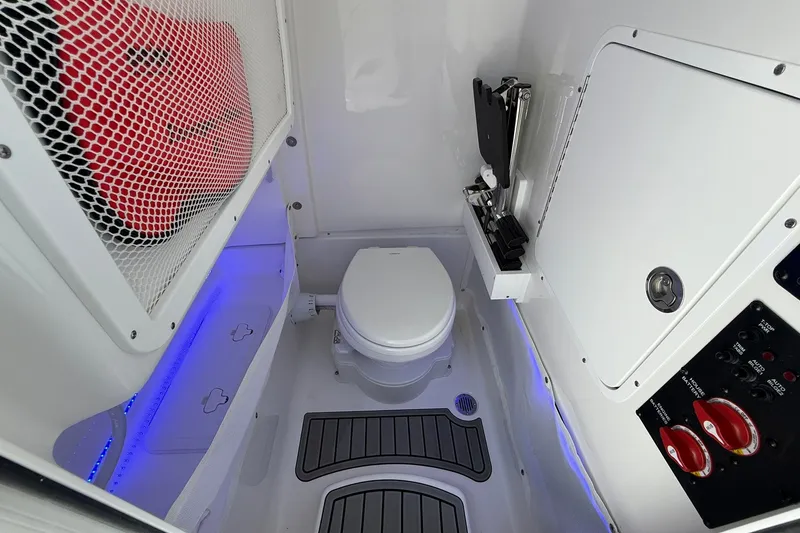 Slide: The Image of 2026 Sea Hunt Gamefish 25 boat interior with toilet, storage, and control panel. - 36