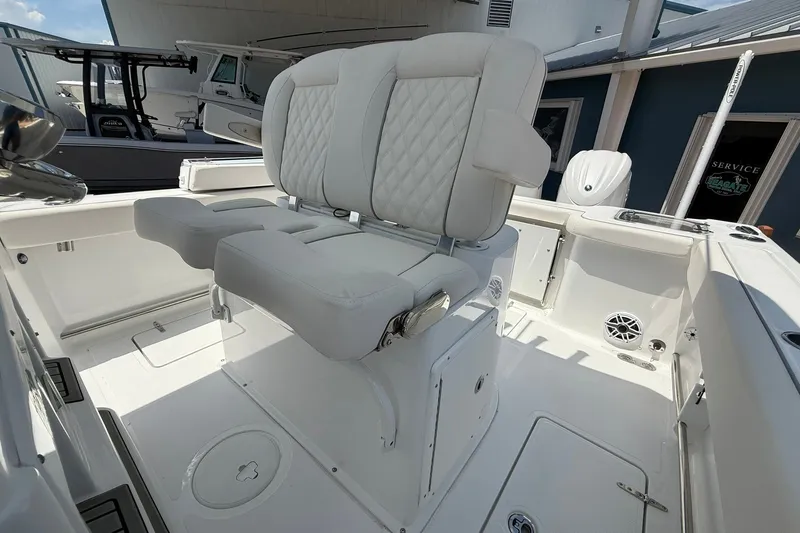 Slide: The Image of 2026 Sea Hunt Gamefish 25 boat interior with white cushioned seating and storage compartments. - 22