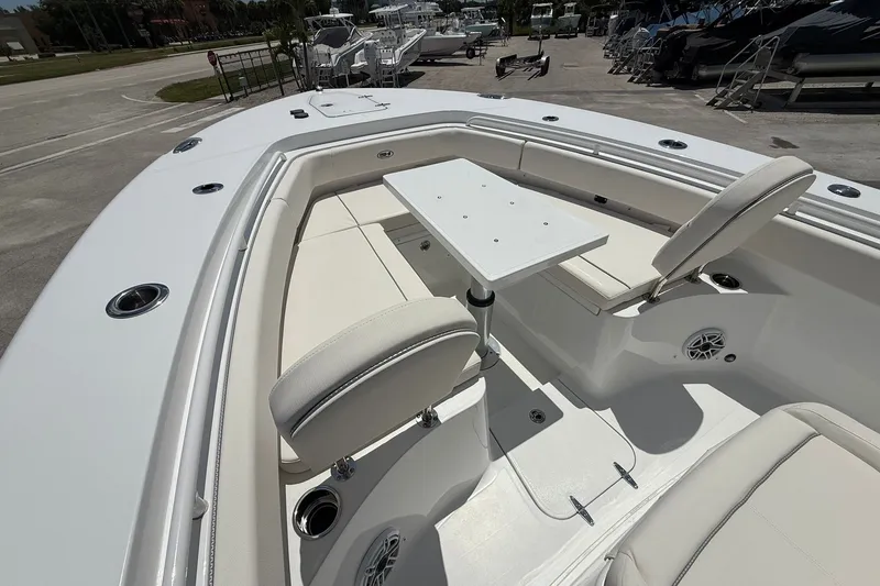 Slide: The Image of 2026 Sea Hunt Gamefish 25 boat interior with seating and table, docked outdoors. - 28