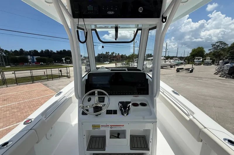 Slide: The Image of 2026 Sea Hunt Gamefish 25 boat cockpit with steering wheel and control panel. - 15