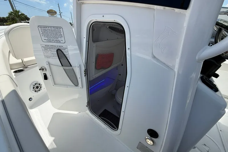 Slide: The Image of 2026 Sea Hunt Gamefish 25 boat interior with open cabin door and visible amenities. - 35