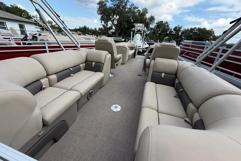 Slide: The Image of 2024 Sun Tracker Party Barge 24 DLX interior with beige seating and spacious layout. - 13
