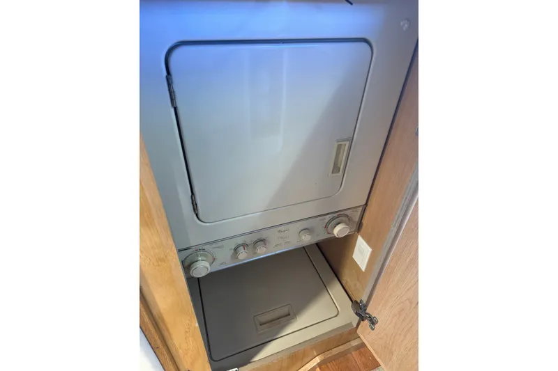 Slide: The Image of Stacked washer and dryer unit inside a 1994 Hatteras 54 Convertible yacht. - 28