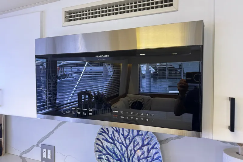 Slide: The Image of A modern microwave in a sleek kitchen with marble countertop and decorative plate. - 32