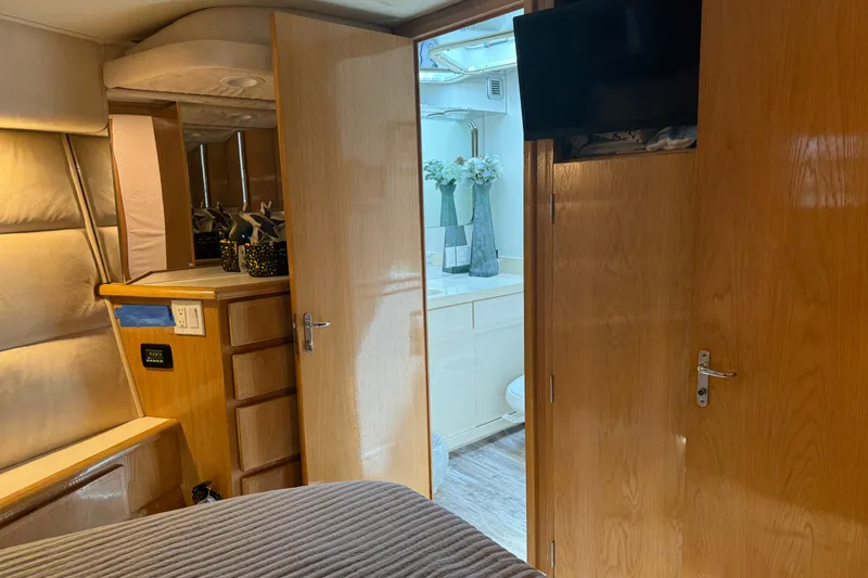Slide: The Image of Interior of 1994 Hatteras 54 Convertible yacht, featuring wood cabinetry and a bathroom. - 25