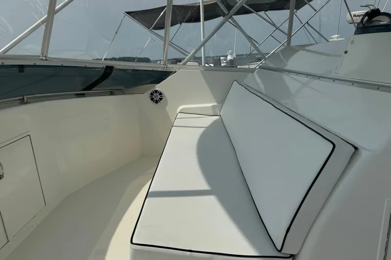 Slide: The Image of Interior seating area of a 1994 Hatteras 54 Convertible yacht, featuring white cushions. - 16