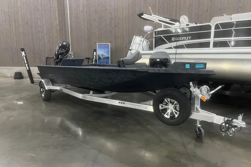 The Image of 2026 Xpress X18DB boat on trailer in showroom setting. - 0