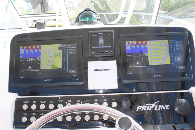 Slide: The Image of 2006 Pro-Line 32 Express boat dashboard with Garmin navigation displays and Mercury controls. - 31