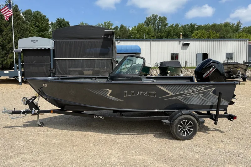 The Image of 2027 Lund 1700 Adventure Sport boat on trailer, parked outdoors. - 1