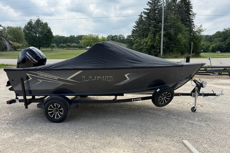 Slide: The Image of 2027 Lund 1700 Adventure Sport boat on trailer, covered, with Mercury outboard motor. - 14