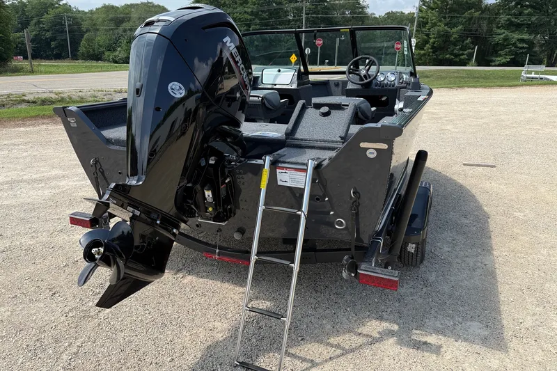 Slide: The Image of 2027 Lund 1700 Adventure Sport boat with Mercury outboard motor and ladder, parked on gravel. - 13