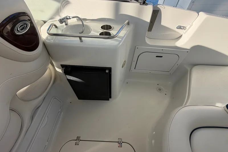 Slide: The Image of 2006 Crownline 290 CR boat interior with sink, fridge, and seating area. - 10