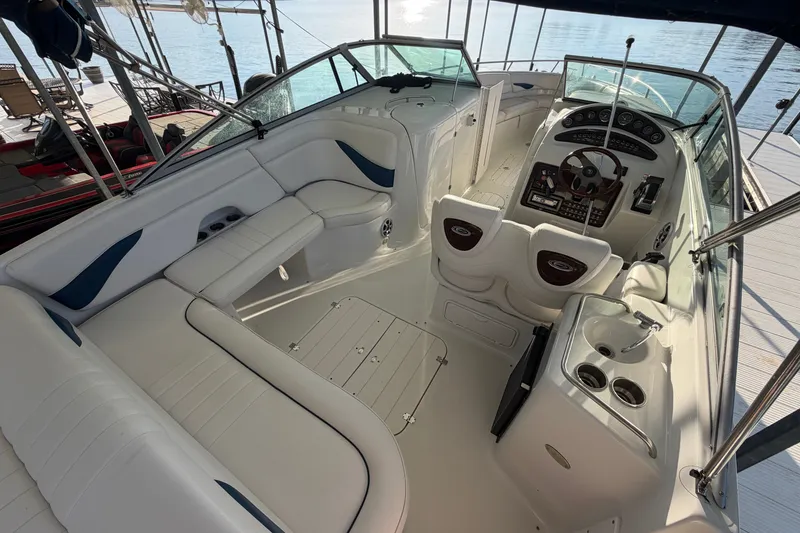 Slide: The Image of 2006 Crownline 290 CR boat interior with helm, seating, and cup holders. - 7