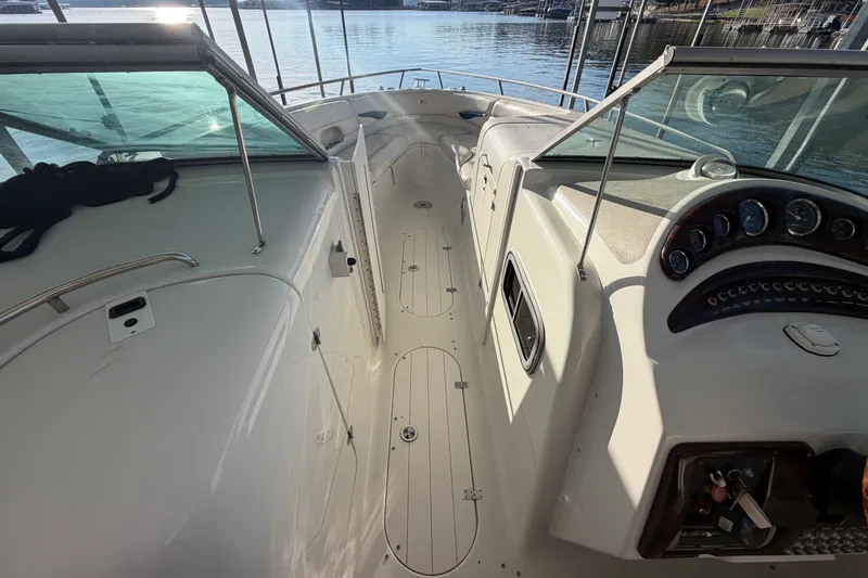 Slide: The Image of 2006 Crownline 290 CR boat interior with dashboard and seating, docked by the water. - 20