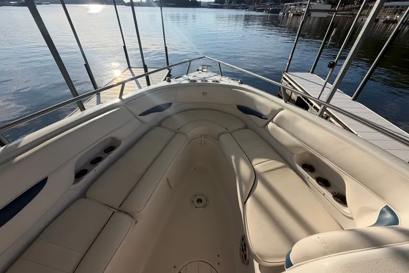 Slide: The Image of 2006 Crownline 290 CR boat interior with spacious seating, docked by calm waters. - 21
