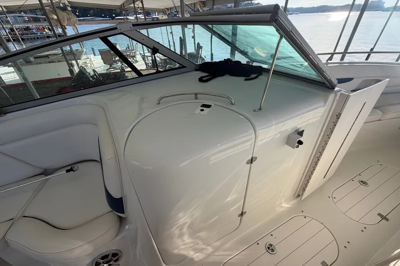 Slide: The Image of 2006 Crownline 290 CR boat interior with white seating and open cabin door. - 18
