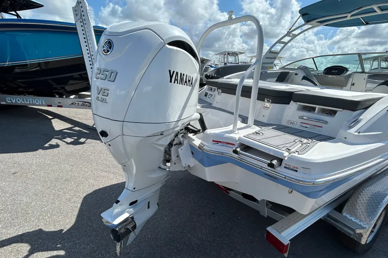 Slide: The Image of 2025 Chaparral 23 SSi OB boat with Yamaha 250 V6 outboard motor, docked under blue sky. - 6