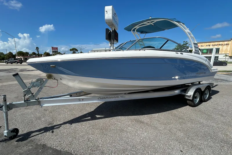 Slide: The Image of 2025 Chaparral 23 SSi OB boat on trailer under clear blue sky. - 2