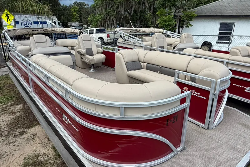 The Image of A red pontoon boat with beige seating, perfect for leisure activities on the water. - 0